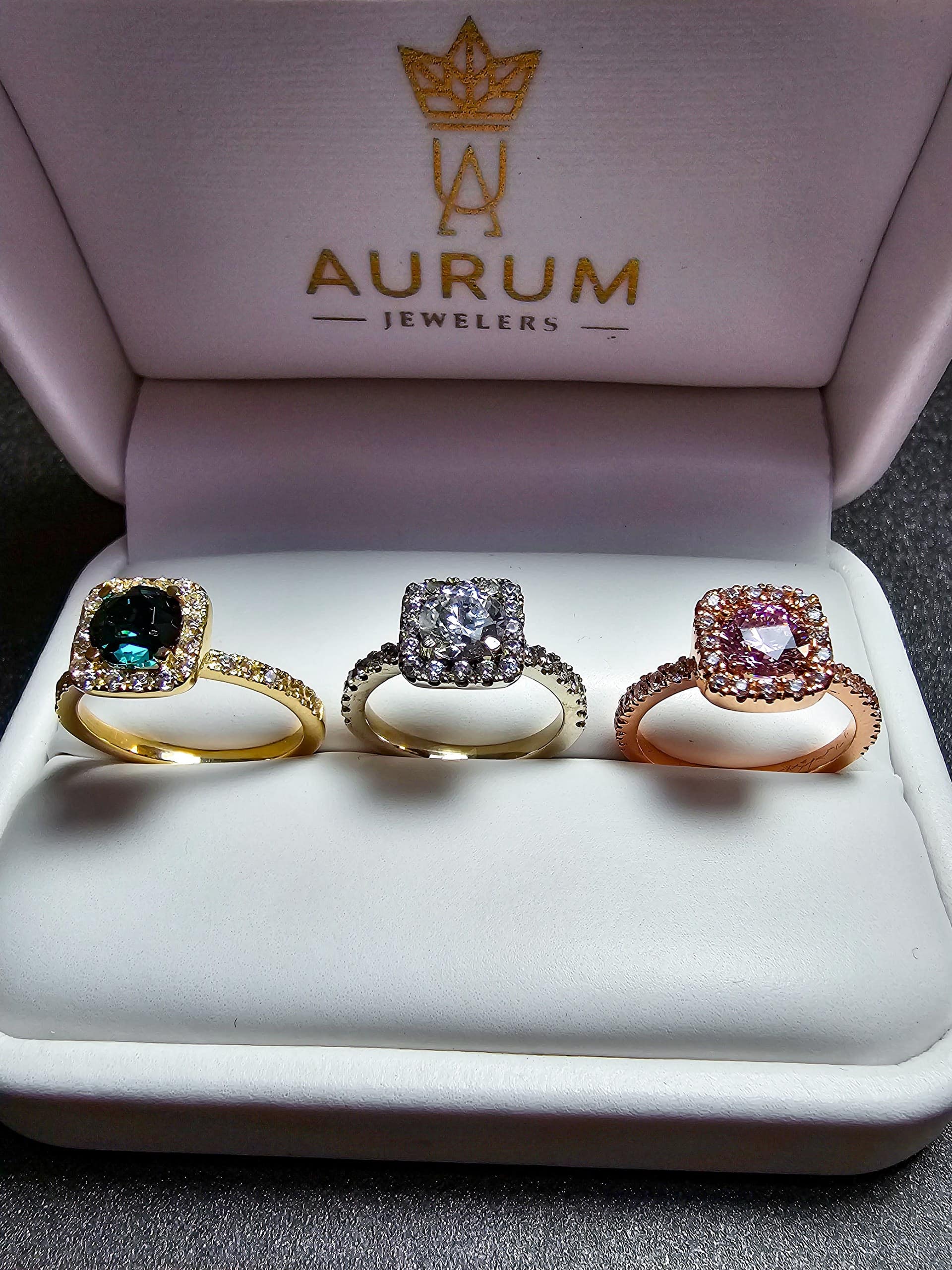 Tres anillos con halo en oro amarillo, oro blanco y oro rosa, lado a lado en estuche Aurum