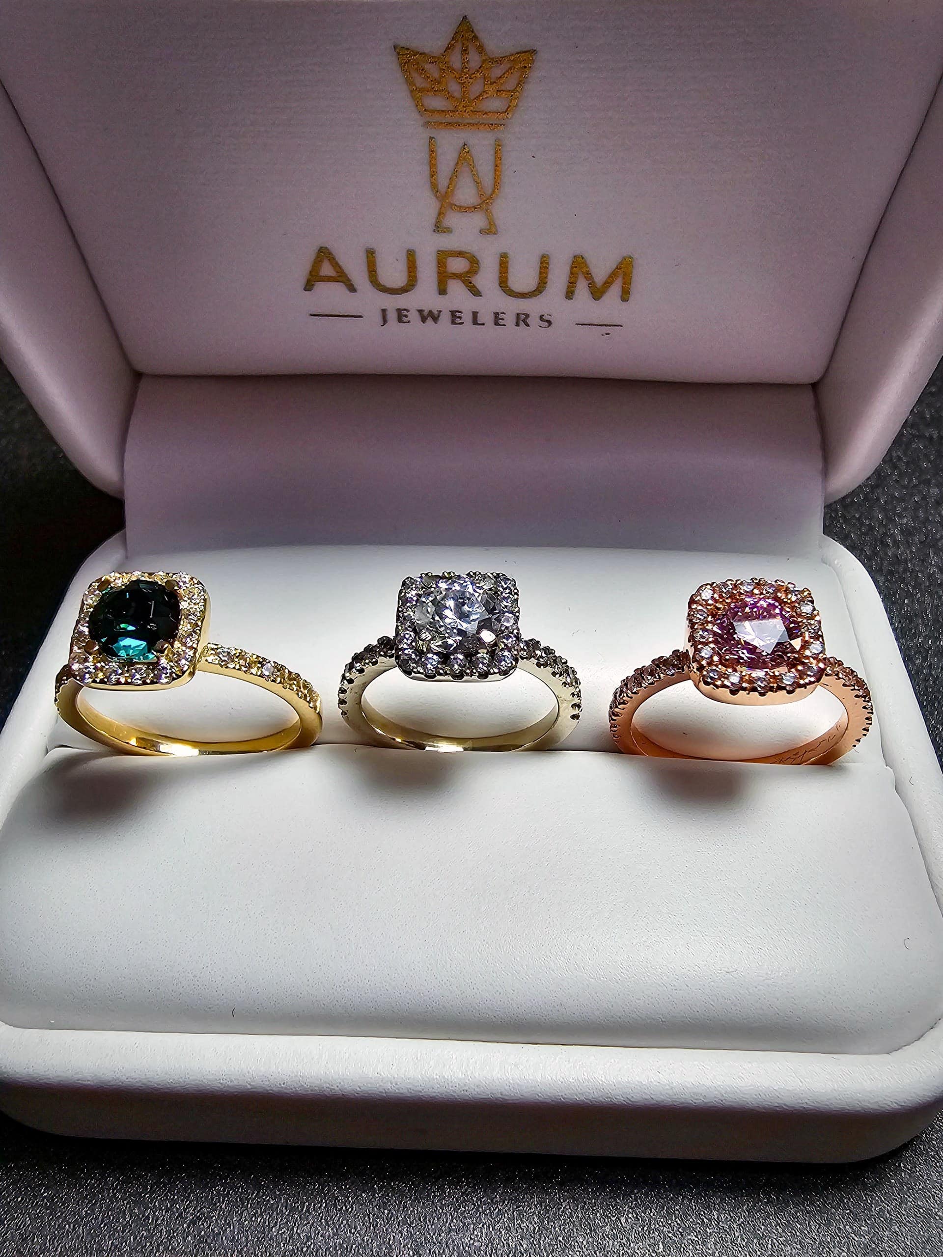 Tres anillos con halo en oro amarillo, oro blanco y oro rosa, lado a lado en estuche Aurum